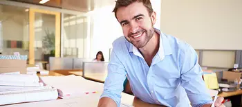Smiling professional man at work using tablet device