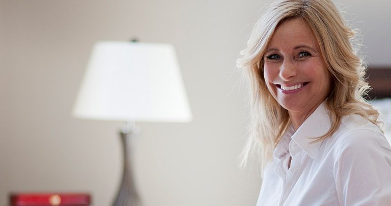Smiling mature professional woman in hotel room