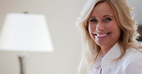 Smiling mature professional woman in hotel room